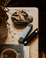 Shinrin-Yoku incense sticks burning in a modern living room setting with natural lighting