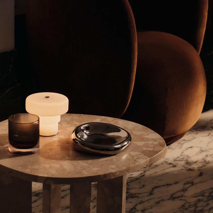 Ripple Portable Lamp, Small, White by ferm LIVING, lit on a side table