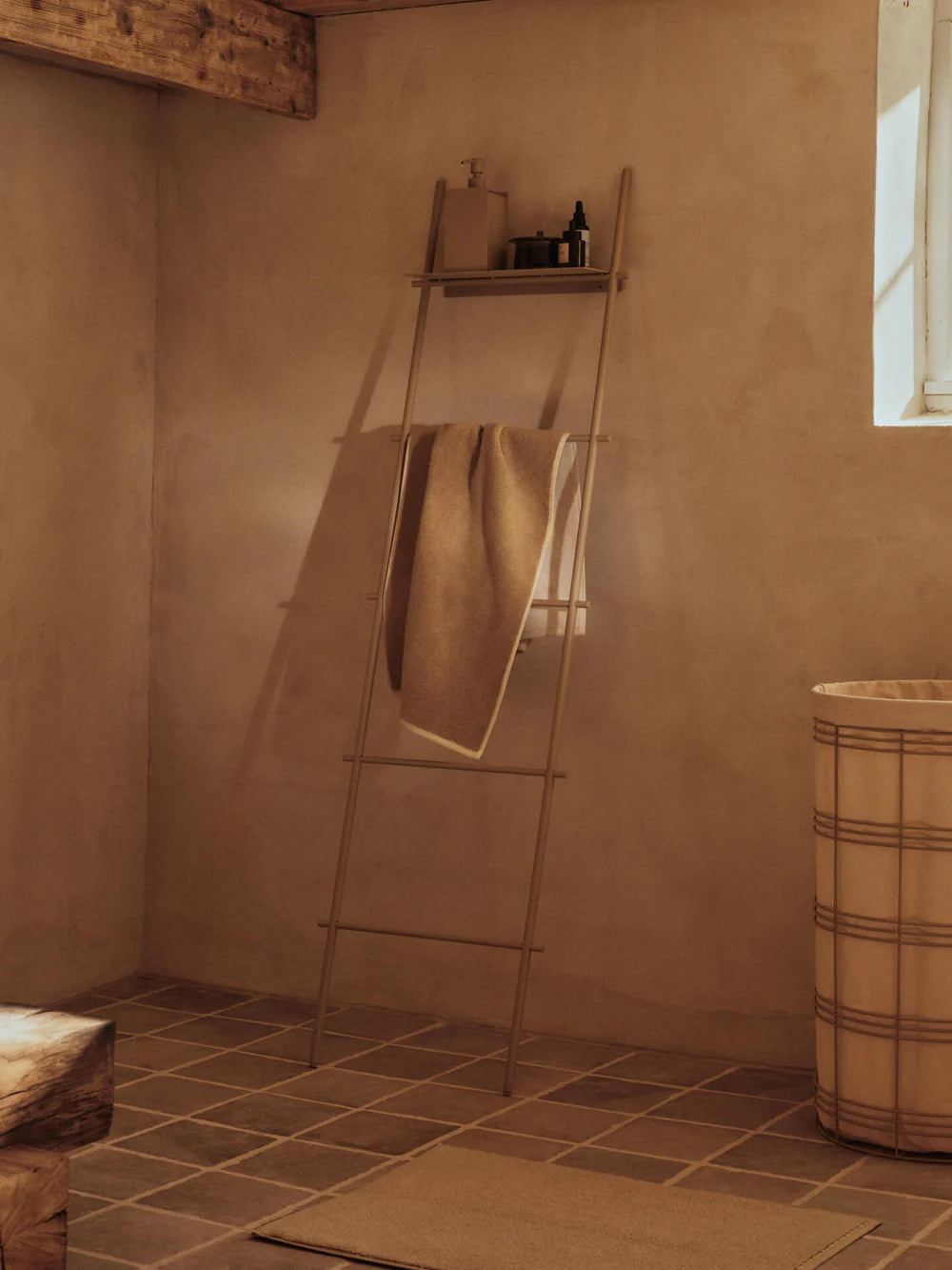 Dora Towel Ladder, Cashmere by ferm LIVING, holding a towel in a bathroom