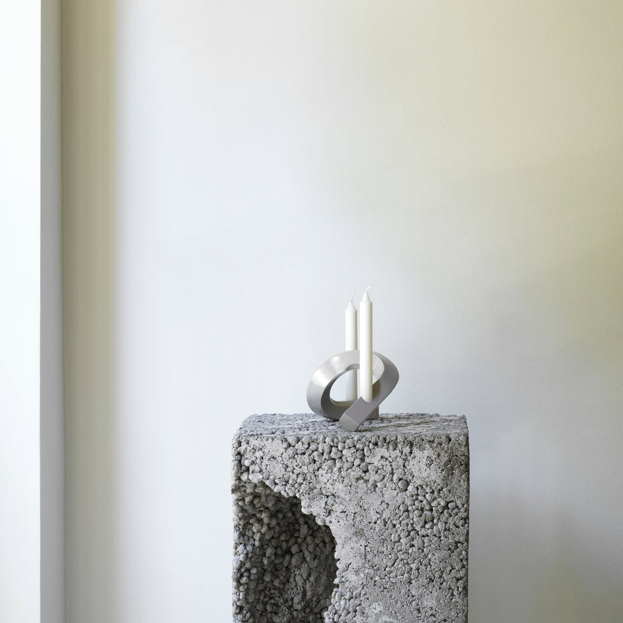 Crooked Candlestick Holder Two, Warm Grey by Normann Copenhagen, on a white plinth