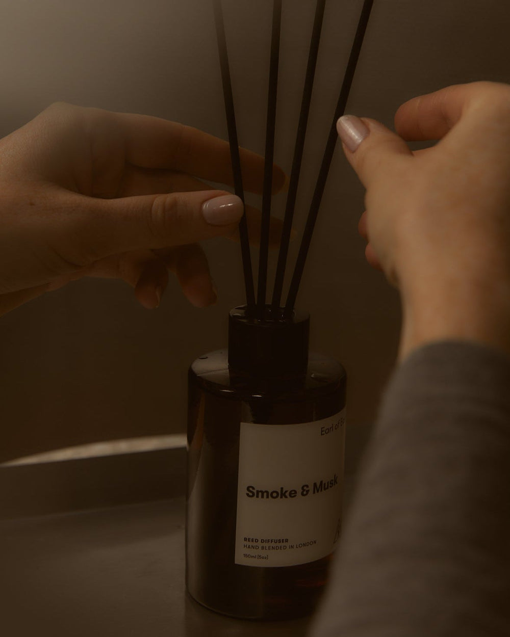Smoke & Musk Reed Diffuser, 150ml by Earl of East, reeds being adjusted by hand