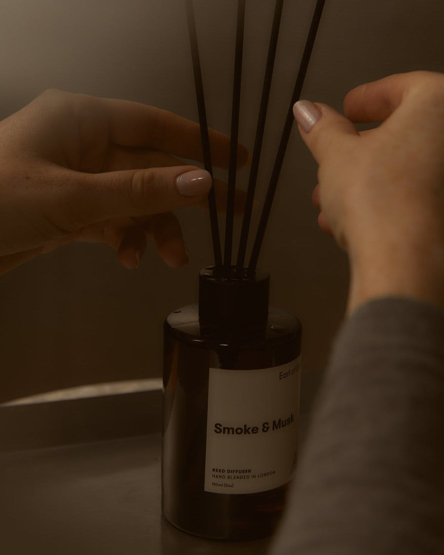 Smoke & Musk Reed Diffuser, 150ml by Earl of East, reeds being adjusted by hand