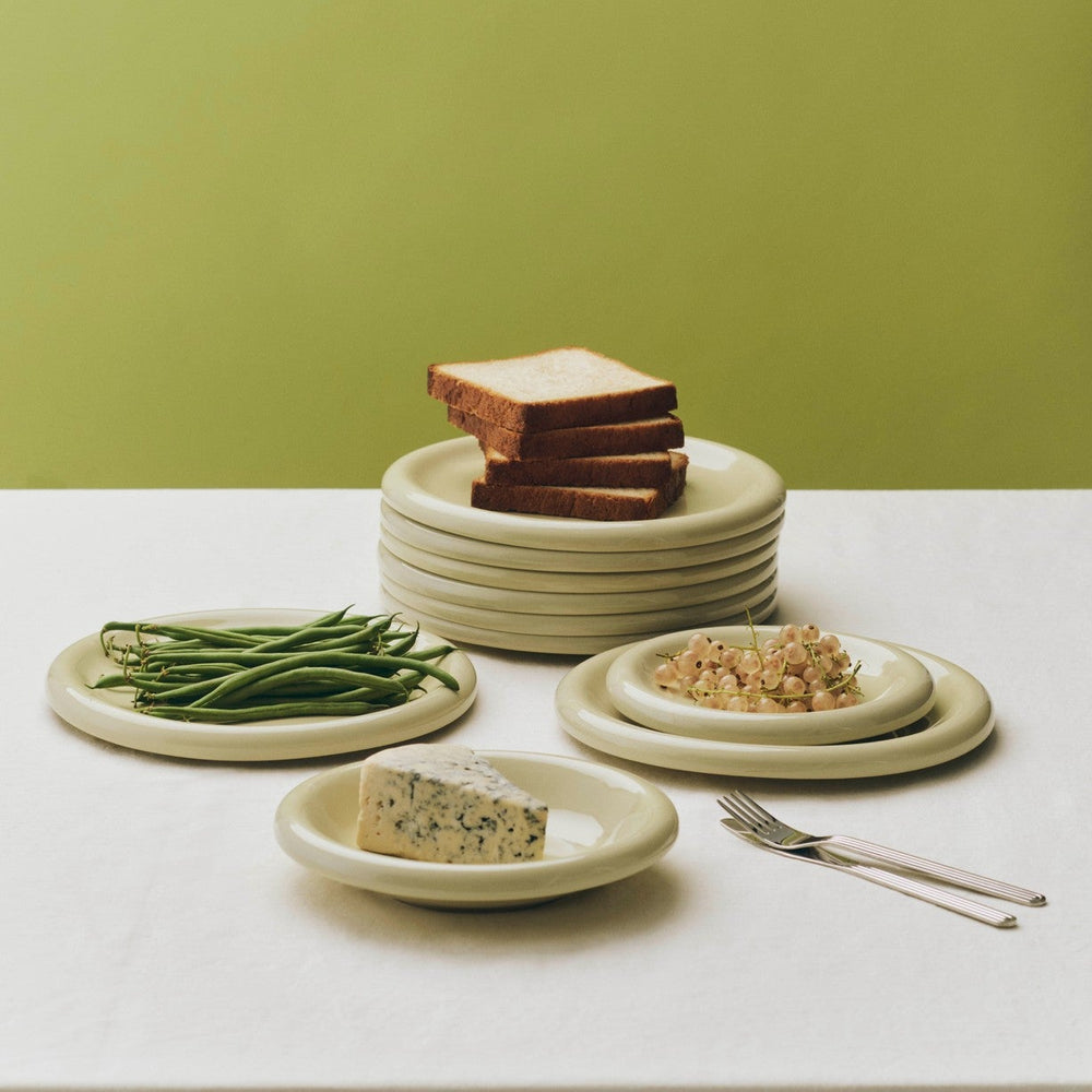 Barro Plate Set of Two, Ø18, Pistachio by HAY, stacked with bread and beans on an olive backdrop