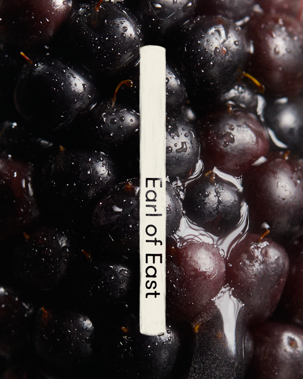 Jardin de la Lune Incense Sticks by Earl of East, tube against dark grapes
