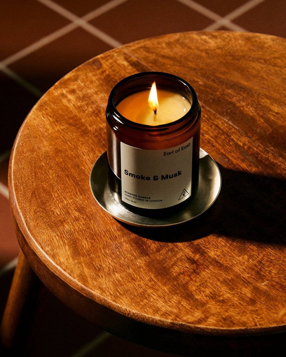 Smoke & Musk Scented Candle, 170ml [6oz] by Earl of East, lit on a marble table