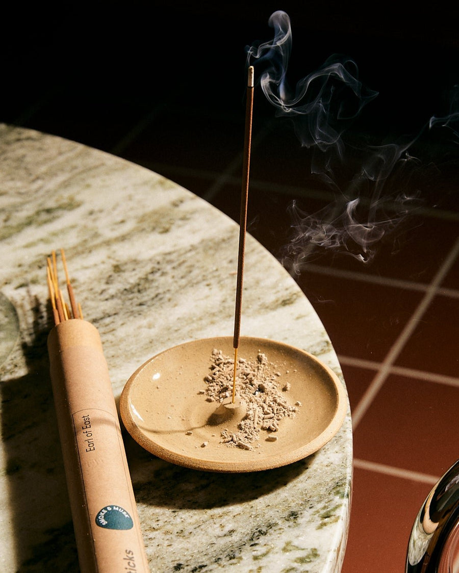 Smoke & Musk Incense Sticks by Earl of East, burning on a marble table