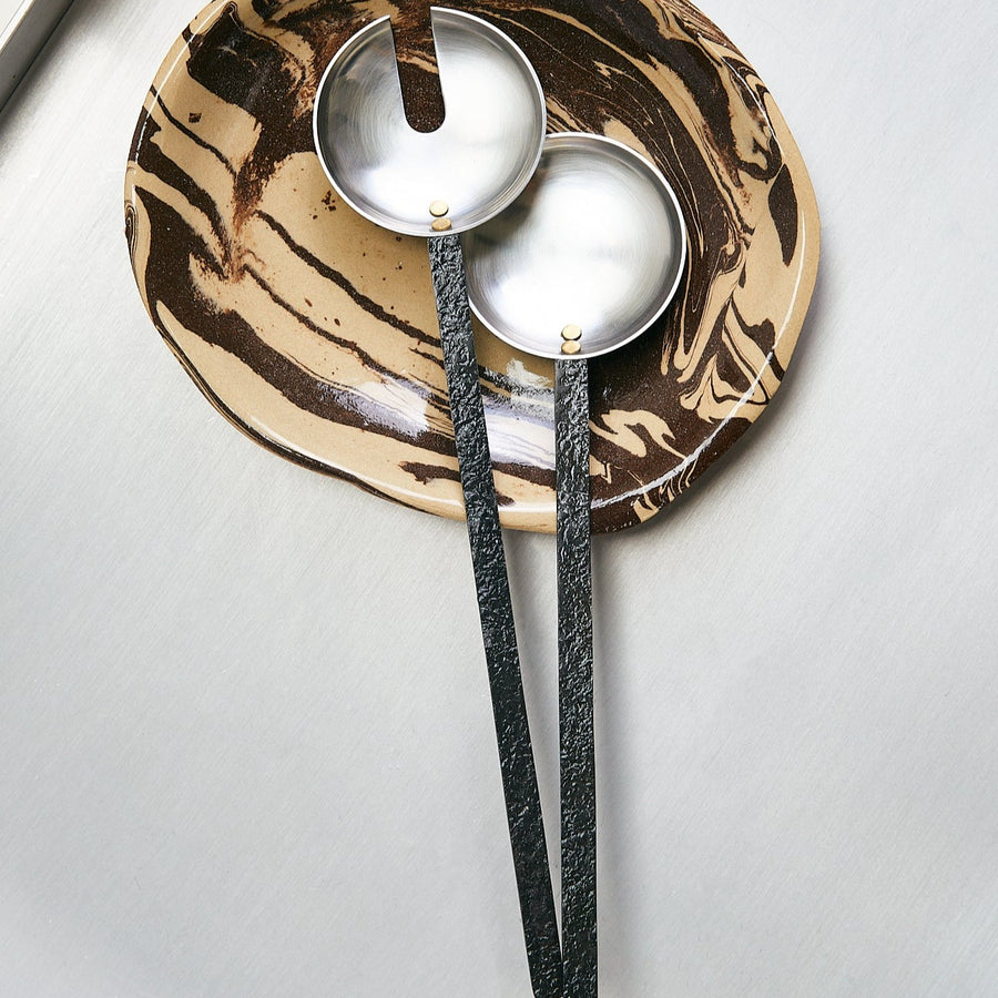 Obra Salad Servers, Stainless Steel by ferm LIVING, on a gold metallic surface