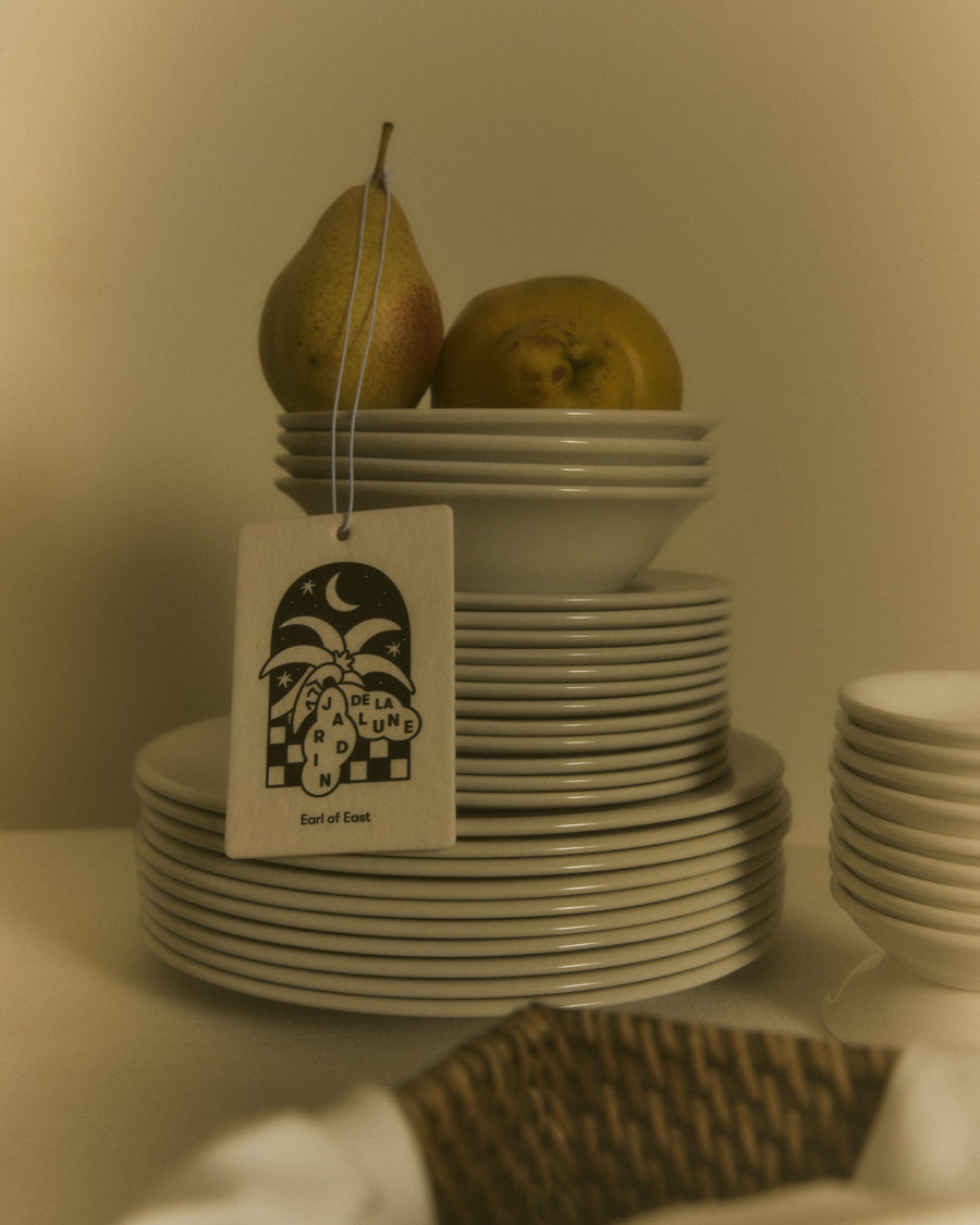 Jardin de la Lune Air Freshener by Earl of East, hanging beside stacked plates and pears