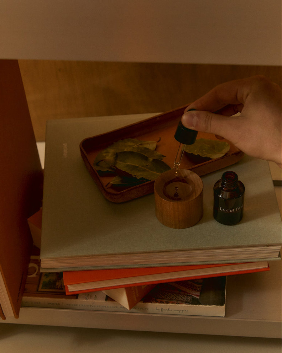 Strand Fragrance Oil Blend, 30ml by Earl of East, with an orange box on a desk