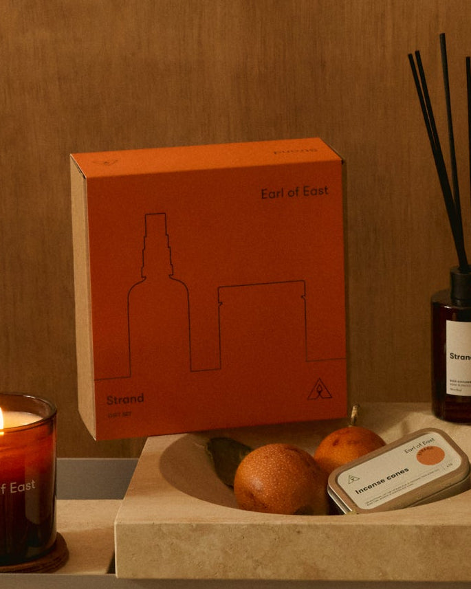 Strand Duo Gift Set by Earl of East, with its orange box on a wooden table