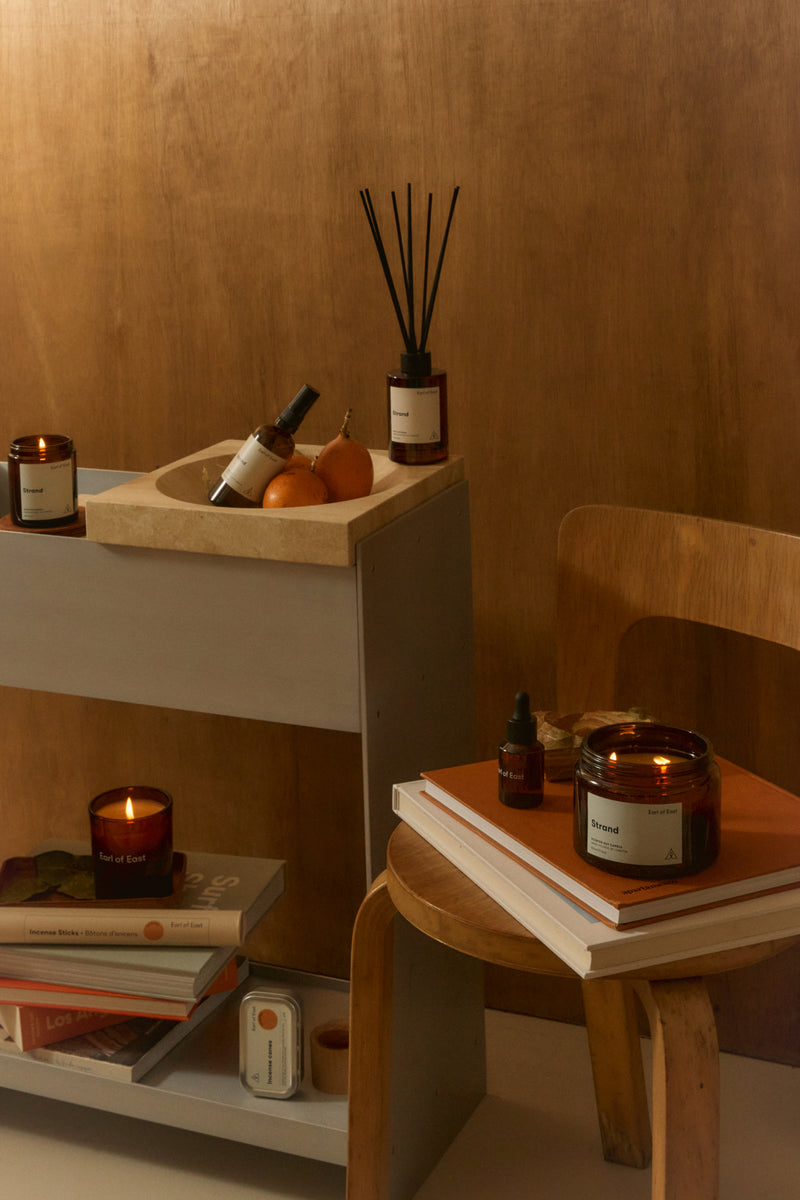 Earl of East Strand candle and diffuser on a wooden shelf