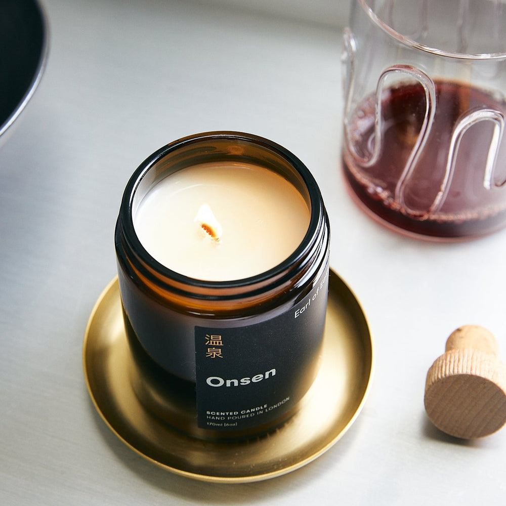 Basho Tray Round, Brass by ferm LIVING, holding a lit Earl of East candle