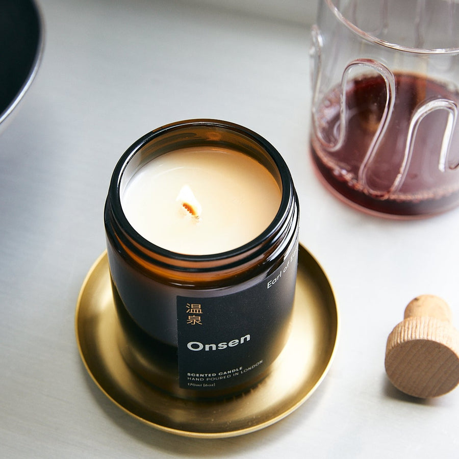 Basho Tray Round, Brass by ferm LIVING, holding a lit Earl of East candle