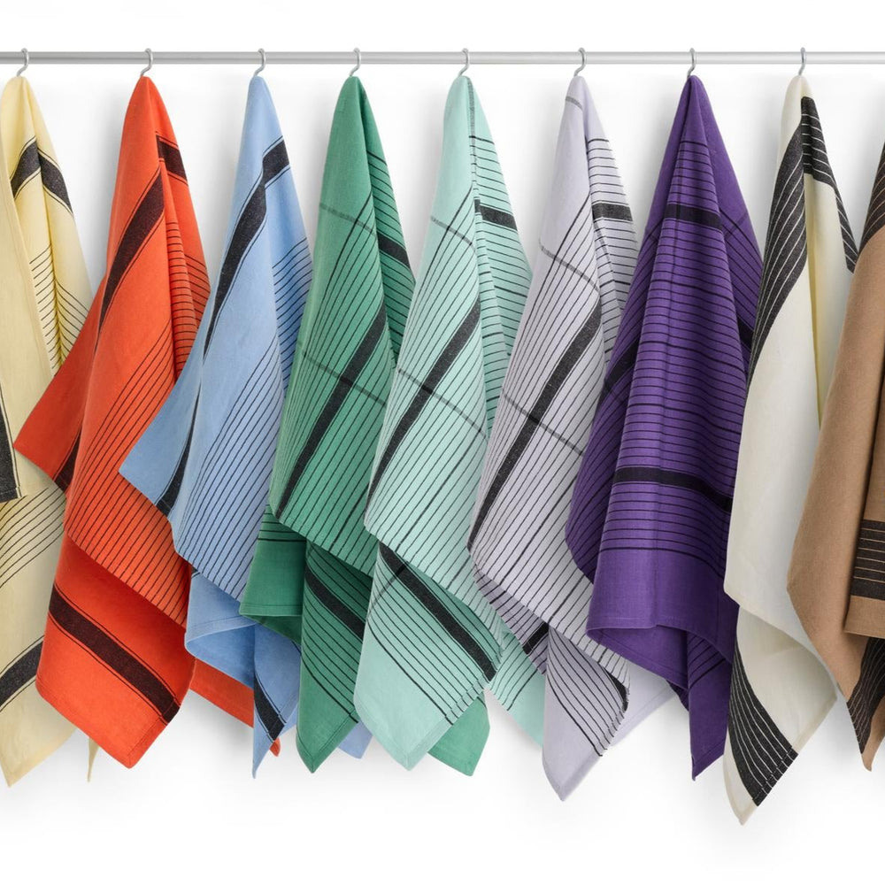 Linear Tea Towel, Sky Blue by HAY, hanging in a range of colours