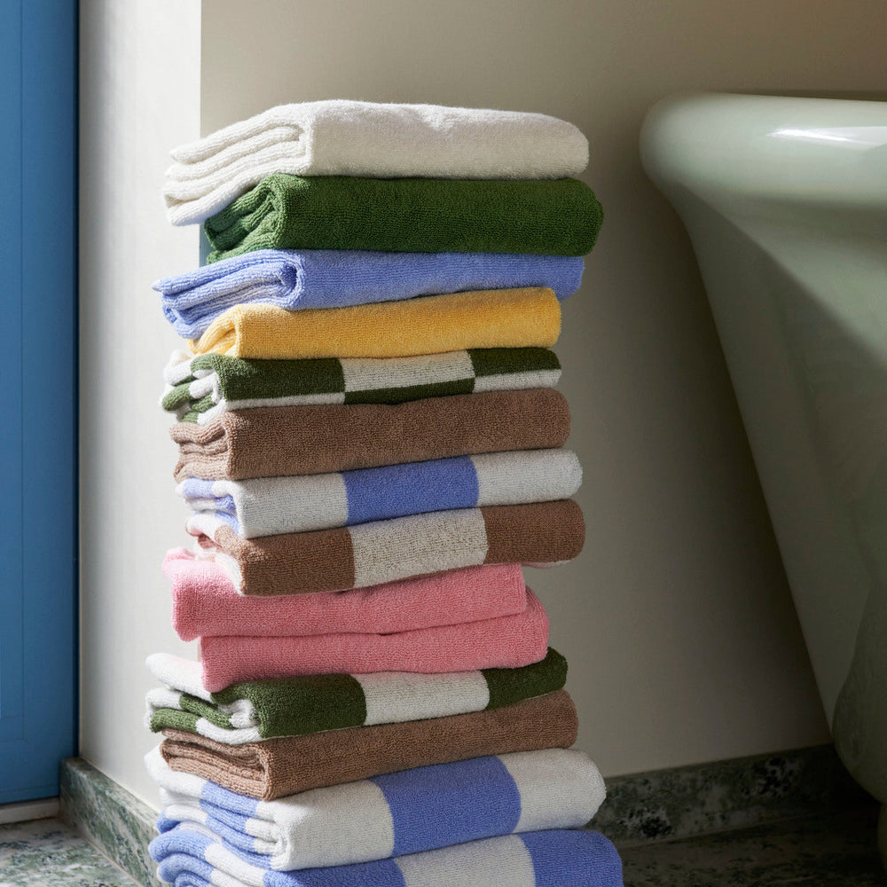 Mono Hand Towel, Sky Blue by HAY, stacked in a range of colours
