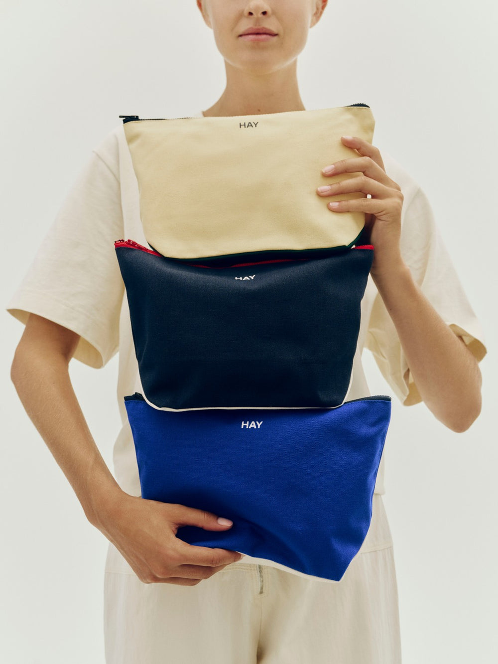 Travel Pouch, Medium, Electric Blue by HAY, held up in a range of sizes