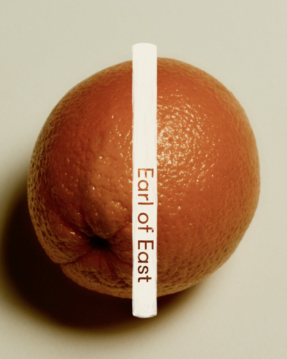 Strand Incense Sticks by Earl of East, tube against a grapefruit