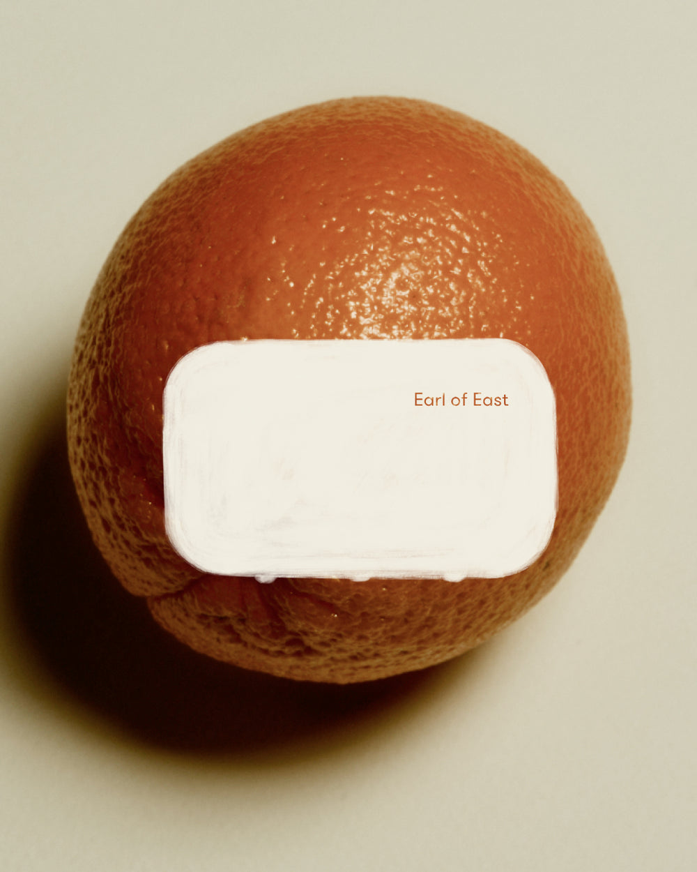 Strand Incense Cones by Earl of East, tin against a grapefruit