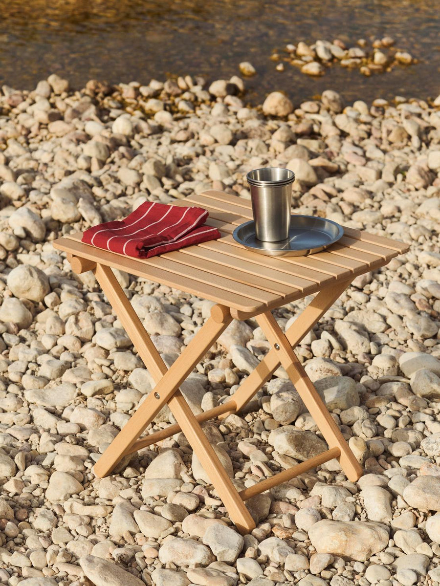 Outdoor Market Tea Towel, Set of 2, Red & Beige by HAY, on a folding table on a beach
