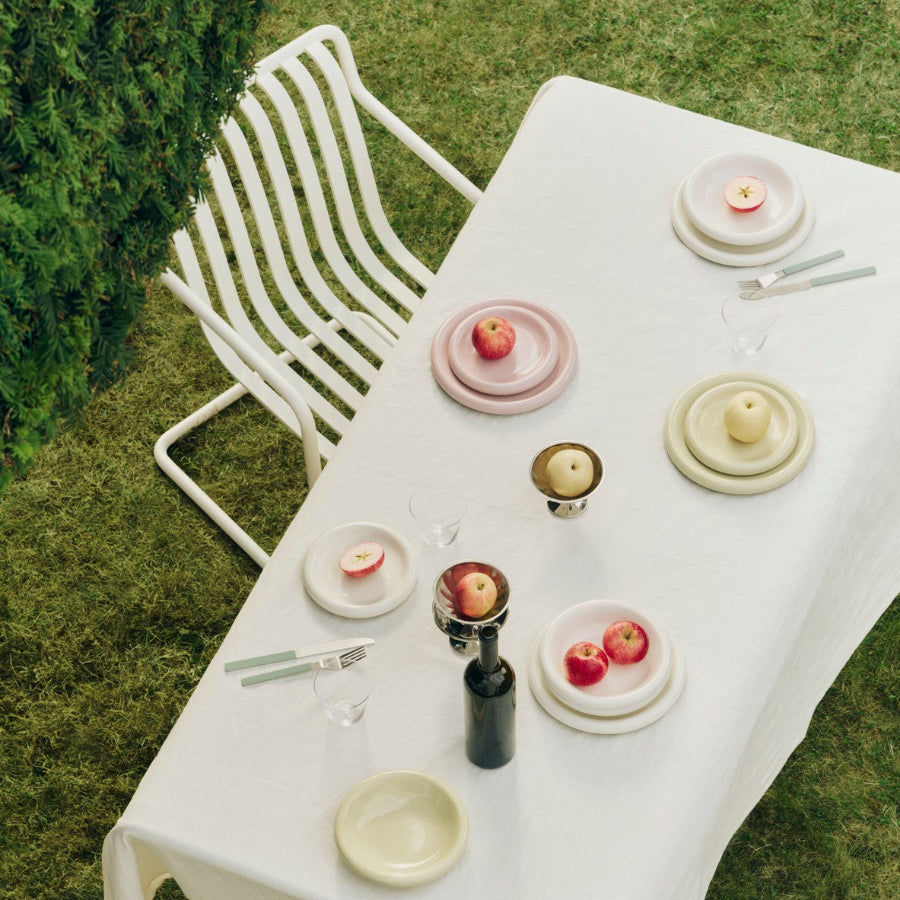 Barro Plate Set of Two, Ø24, Pistachio by HAY, on an outdoor table on grass
