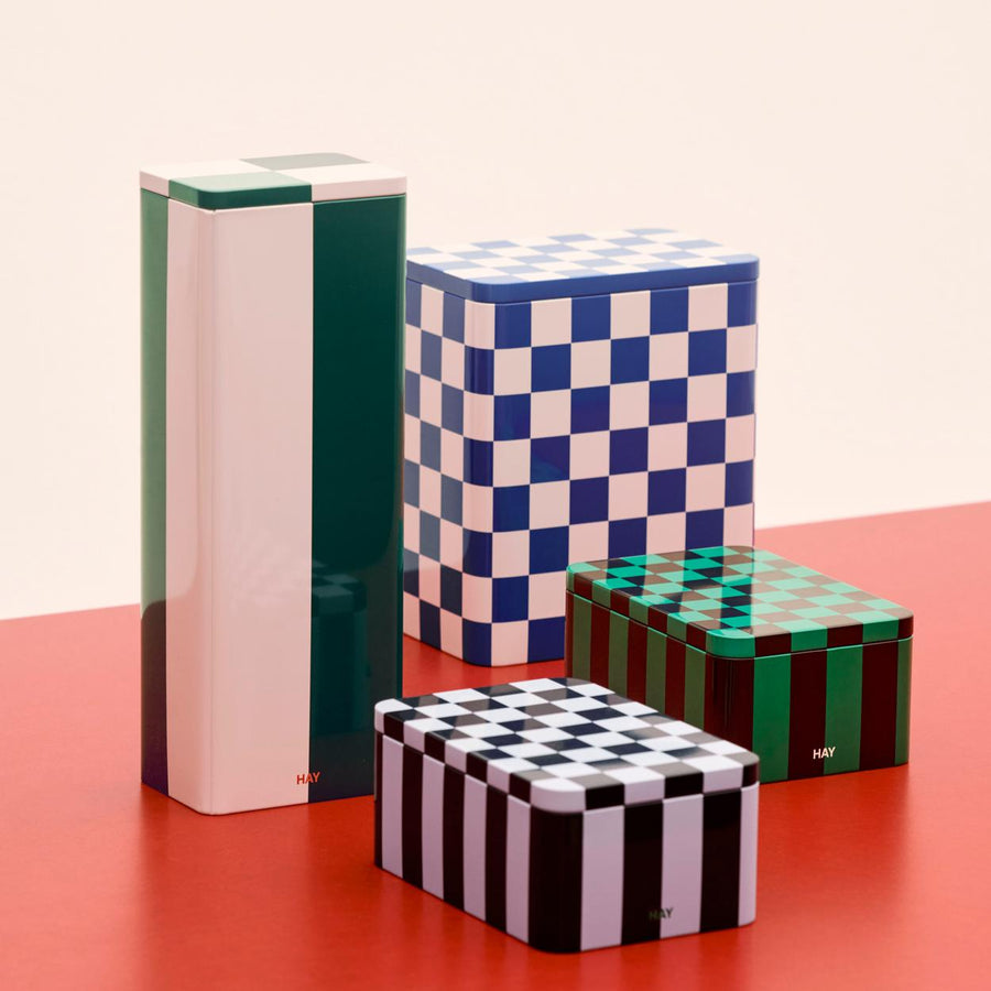 Tin Container, Small, Dark Blue & Lavender by HAY, stacked on a red shelf
