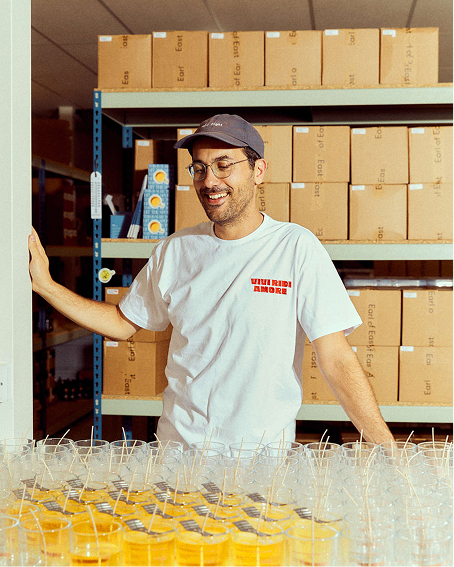 Smiling man holding a tray of Earl of East Primavera candles at the studio