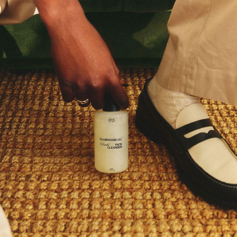 Frontier Face Cleanser, 225ml by Clubhouse Skin, being held in a hallway