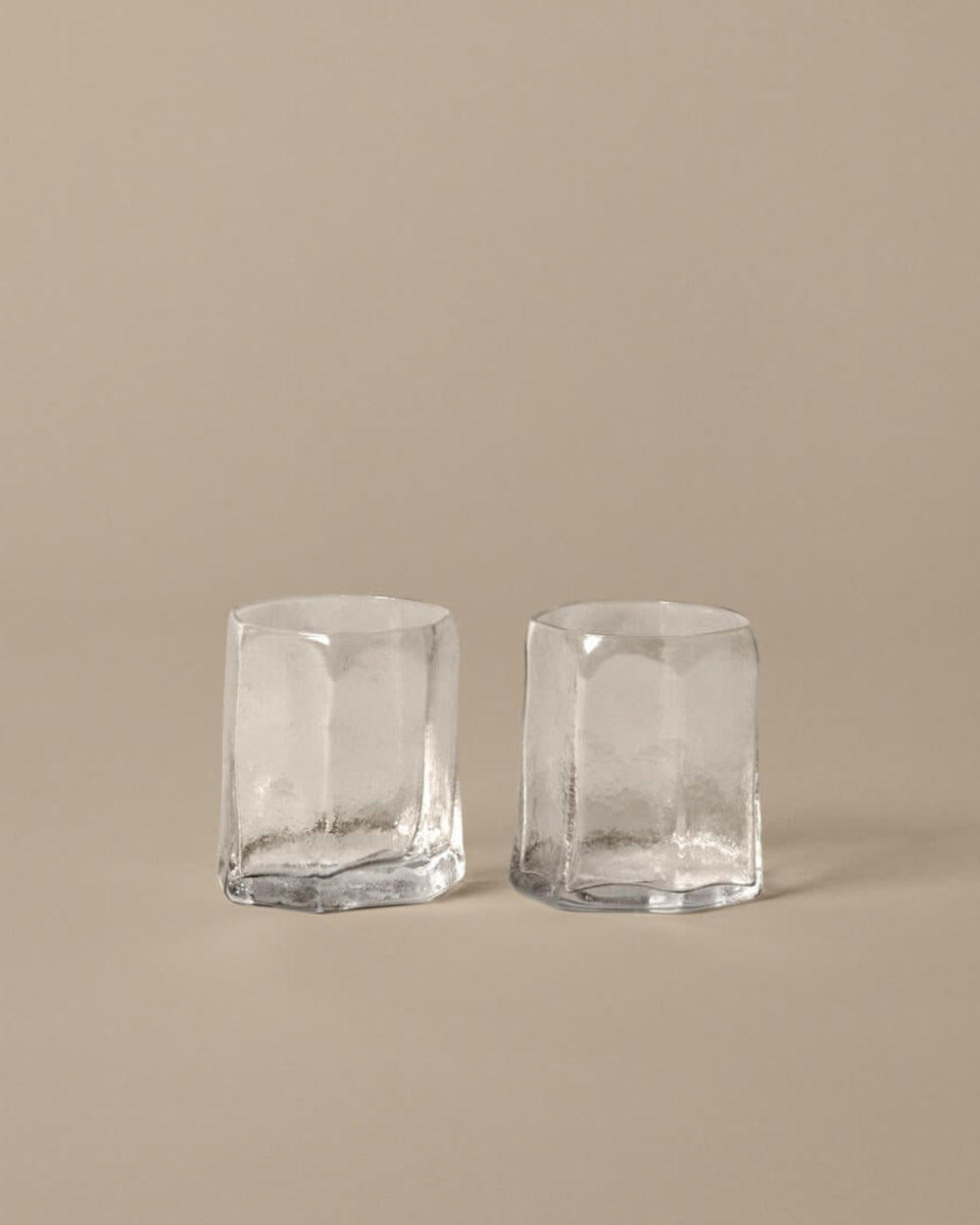 Kiru Glasses, Set of 2, Clear by ferm LIVING, on a beige background