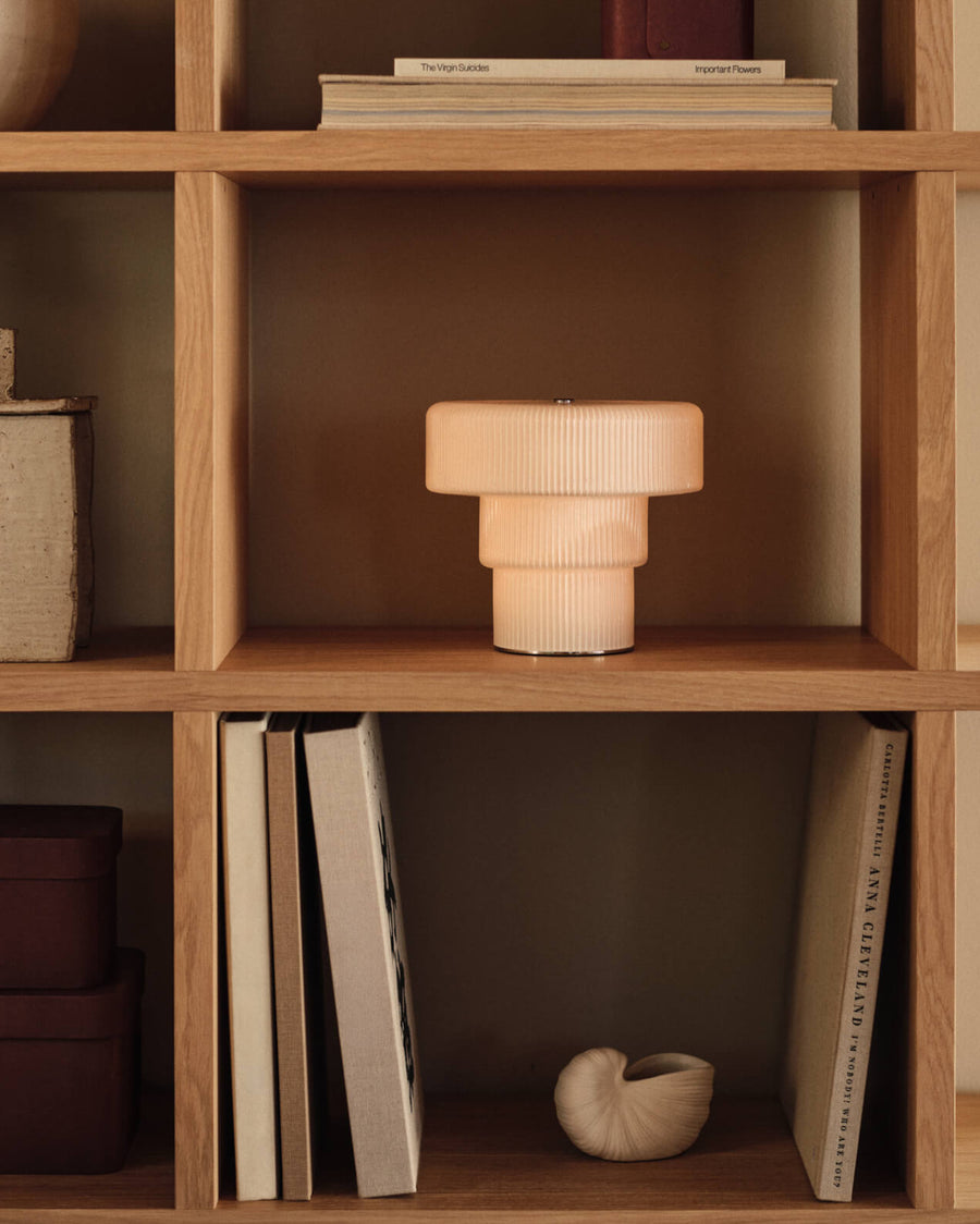 Ripple Portable Lamp, Large, White by ferm LIVING, on a bookshelf