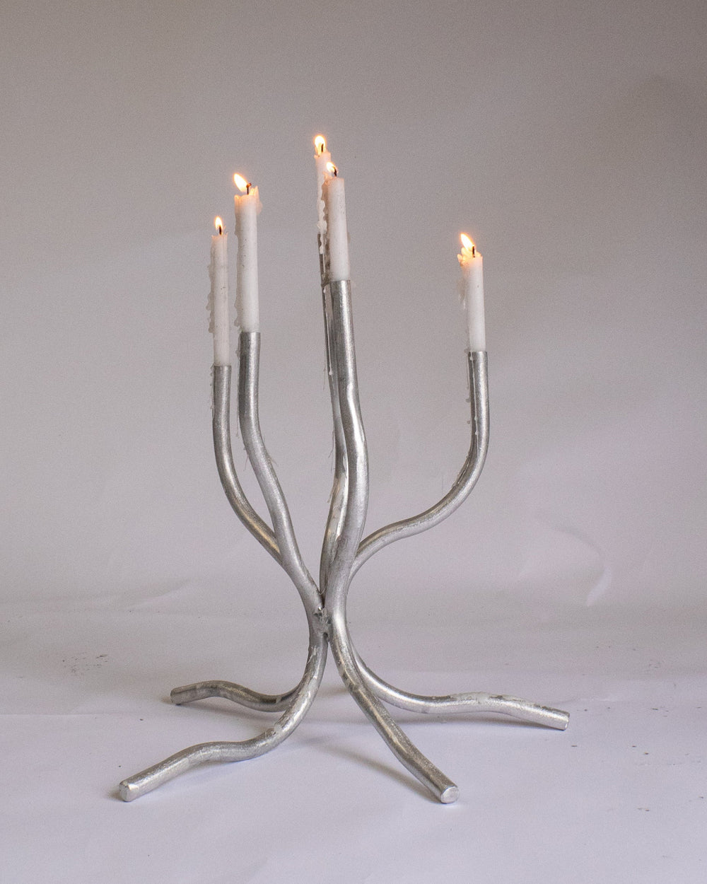 Small Candelabra, Aluminium by Six Dots Design, holding lit tapers
