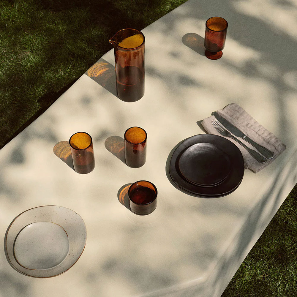 Staffa Coffee Table, Large, Ivory by ferm LIVING, holding glassware outdoors
