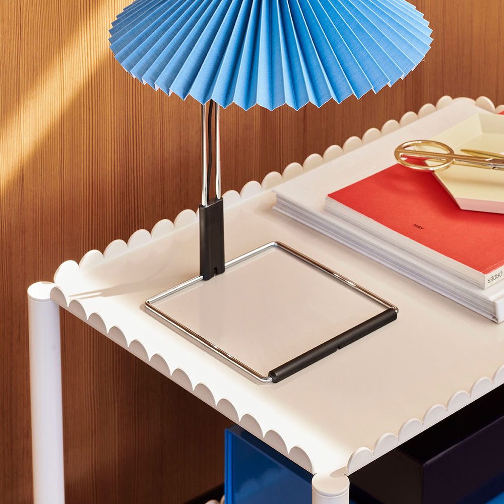 Arcs Trolley, High, Eggshell by HAY, with a blue lamp on top in a white room