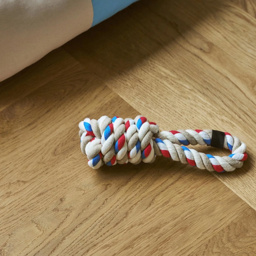Dogs Rope Toy, Red/Turquoise/White by HAY, on a wooden floor