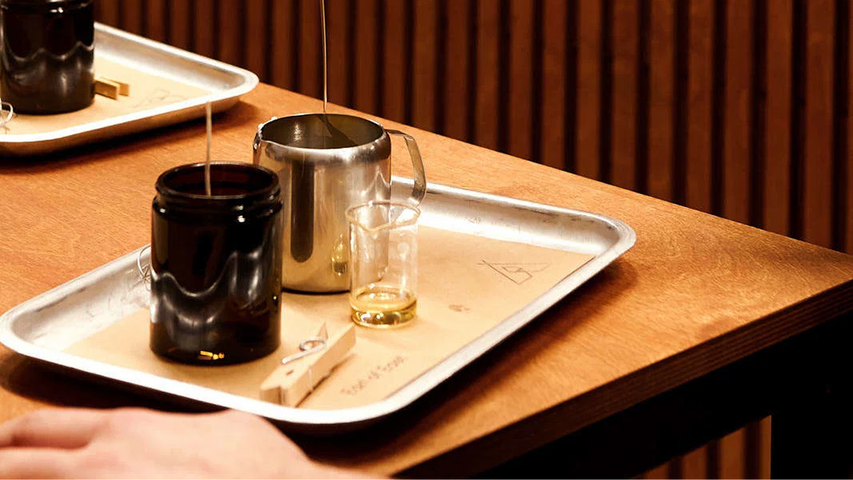 Wooden tray with metal pouring jugs on a counter in warm light