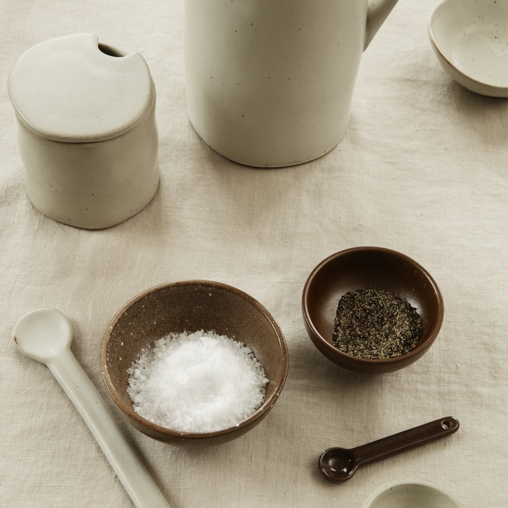 Flow Jam Jar, Off White by ferm LIVING, on a stone counter with salt