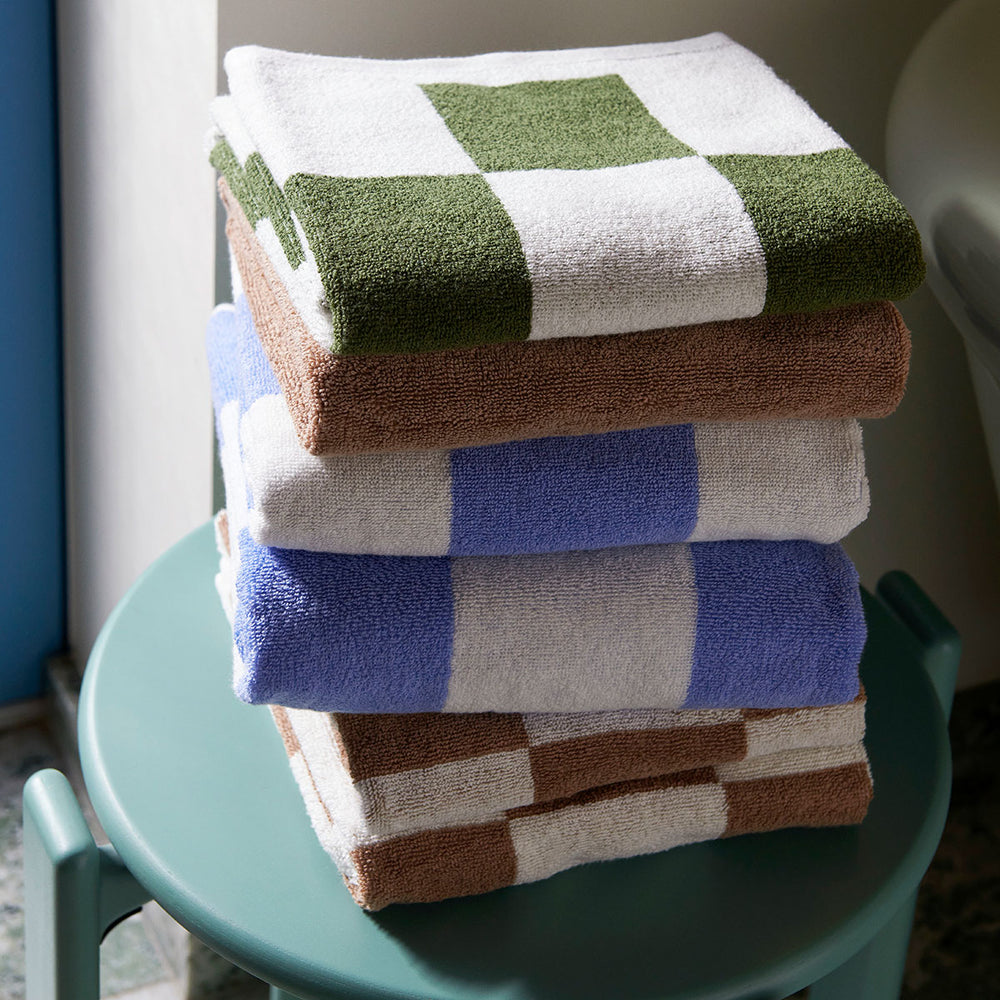 Cotton Hand Towel in Sky Blue by HAY, stacked in a range of colours
