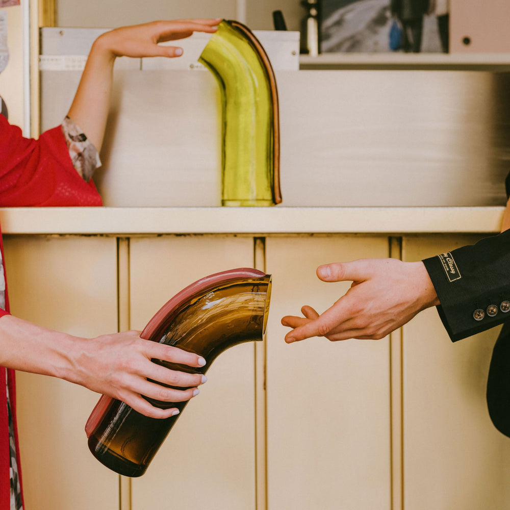 NESSIE Carafe, Lime with Brown Stripe by Ursula Futura, being passed between hands